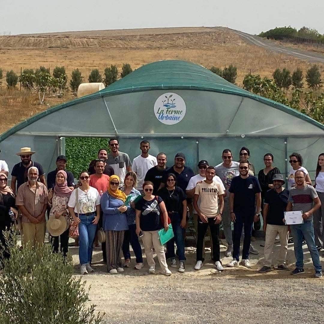 L'équipe et des participants réunis devant une serre La Ferme Urbaine en Tunisie